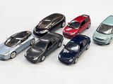 plusieurs petites voitures sont alignées sur une surface blanche