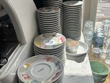 many plates and bowls on the counter in the kitchen