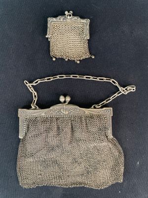 two silver mesh purses with pearls hanging from them
