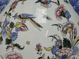 a white vase with blue flowers and birds on it