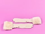 une paire de gants blancs à poignets fourrés sur fond rose