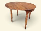 une table en bois à deux pieds avec un plateau rond