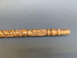 an old wooden pipe with carvings on it sitting on a table