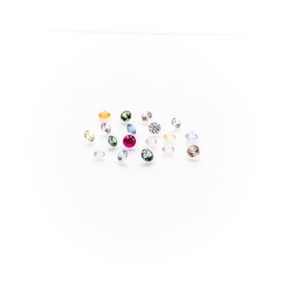 a bunch of different colored stones sitting on top of a white surface