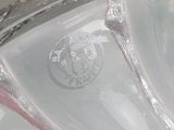 a close up of a clear glass bowl with a red handle