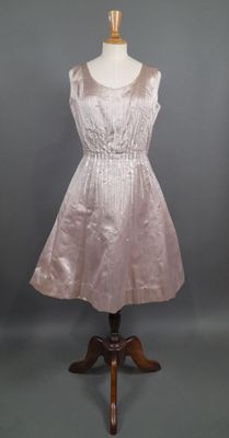 une robe posée sur un présentoir à mannequin, sur fond gris