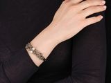 une femme portant un t-shirt noir et un bracelet en or