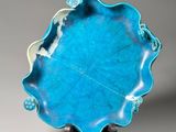 a close up of a blue plate on a stand on a gray background