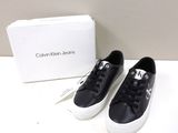 black leather sneakers with white soles and a box on a white surface