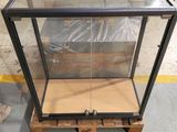 an empty glass display case sitting on a pallet in a warehouse