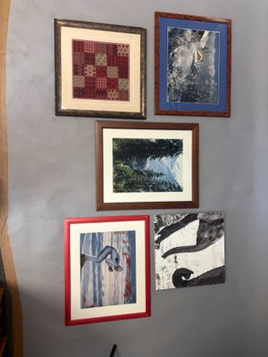 many pictures hanging on the wall of this room