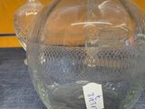 a glass vase with a tag on it sitting on a table