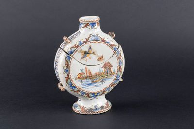 un petit vase avec un tableau posé sur une table