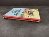 an old children ' s book sitting on top of a black surface