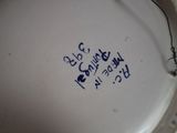a close up of a white vase with blue writing on it