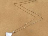 the white mother of pearl necklace is shown on a gold chain