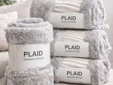four white towels stacked on top of each other on a bed