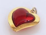 a red glass heart shaped pendant on a gold plated chain