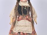 a doll that is wearing a dress and a hat