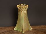 a green vase sitting on a table with a black background