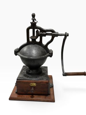 an old coffee grinder with a wooden base and a wooden handle