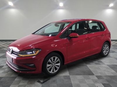Une Volkswagen e-Golf rouge est garée sur un sol à damier.