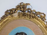 a picture of a woman in a blue dress in front of a gold frame
