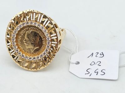 a close up of a gold ring with a coin on top of it