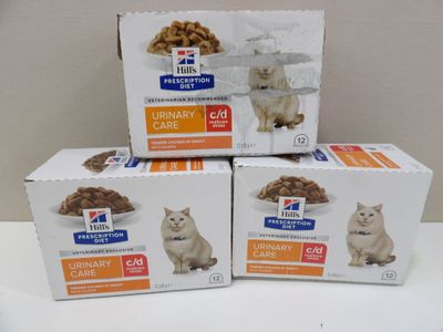 trois boîtes d'aliments pour chats Hill's sur ordonnance posées sur une table