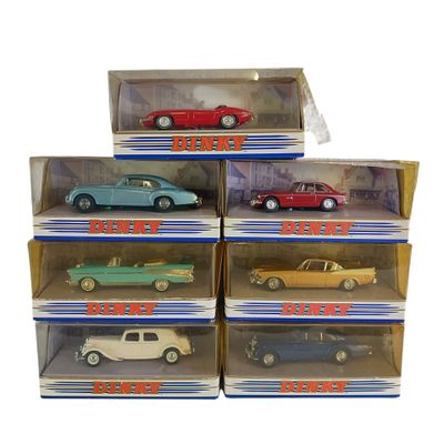 Plusieurs petites voitures sont exposées dans une vitrine posée sur une surface blanche