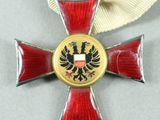 an image of a red and gold cross with a white ribbon