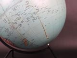 a blue globe on a metal stand with a map on it