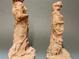 pair of statues of a woman and a man on a rock
