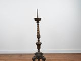 an antique wooden candle stand with a candle on top of it