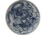 une assiette bleue et blanche ornée d'un dragon