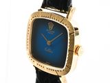 a close up of a gold watch with a blue face
