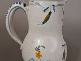 a white vase with a blue and yellow design on it