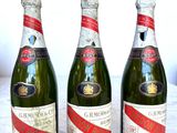 Trois bouteilles de champagne sont alignées sur une table en marbre