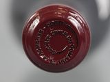 a close up view of a wine bottle with a red cap