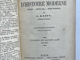 a book open on a table with a picture of a building in the background