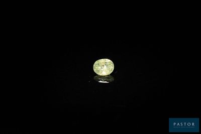 a close up of a yellow diamond on a black surface