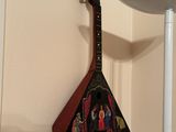 a guitar hanging on the wall next to a lamp