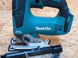 a close up of a corded jig saw on a piece of plywood