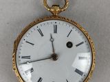 une montre de poche en or avec des chiffres romains sur le cadran