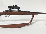 un fusil posé sur un support transparent, avec une arme dessus