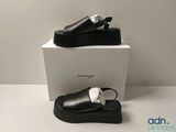 the black shoes are sitting on top of a white box