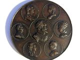a picture of a bronze medal with a group of people on it