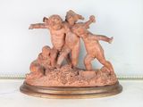 a statue of three children playing with a ball on a table