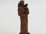 figurine of a woman holding a child on a wooden base
