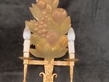 a gold and white figurine sitting on a gold chair